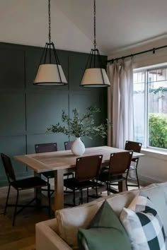 a living room with a couch, table and chairs in front of a large window