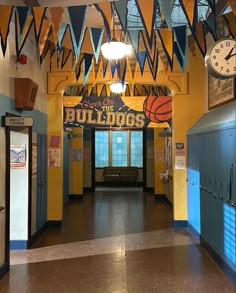 an image of a school hallway with flags hanging from the ceiling and lockers on the walls