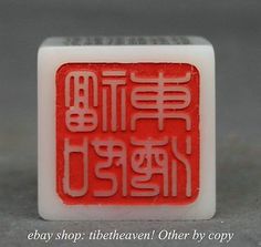 a red and white object with chinese writing on it's side, in front of a gray background