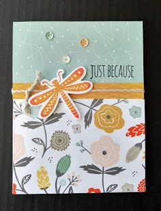 a card with a dragonfly on the front and flowers on the back that says, just because