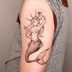 a woman with a mermaid tattoo on her arm