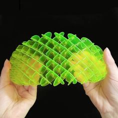 two hands holding green and yellow plastic objects