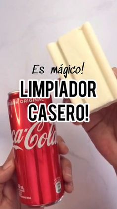 a hand holding a can of coca cola and a piece of white paper with the words, es magico limpiador casero