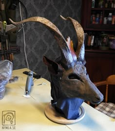 a deer head with horns on top of a table