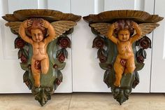 two statues of cherubs on the wall next to each other