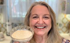 a woman holding a pie in front of her face and looking at the camera with an excited look on her face