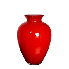 a red vase sitting on top of a white table