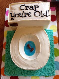 a birthday cake that says crap you're old on top of a toilet bowl