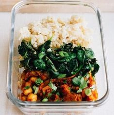 a glass container filled with rice, spinach and chickpeas