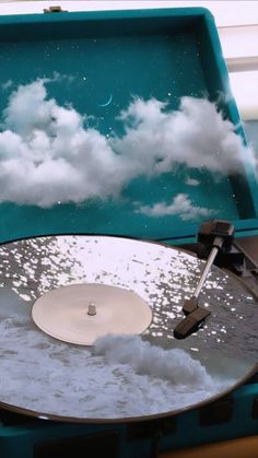 an old record player with clouds in the background