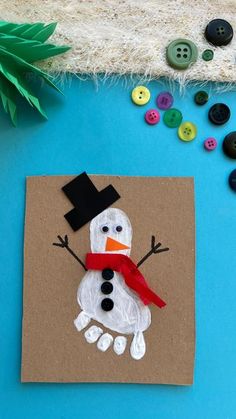 a craft made to look like a snowman on a piece of cardboard with buttons around it