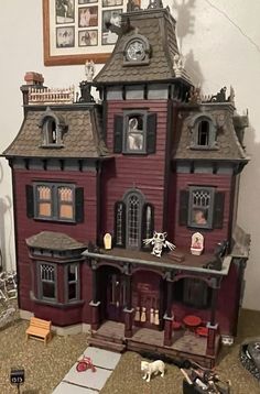 a doll house with lots of furniture and accessories on the floor in front of it