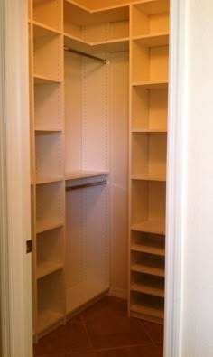 an empty walk in closet with white shelves