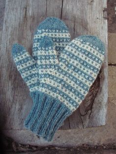 a blue and white mitten sitting on top of a wooden table