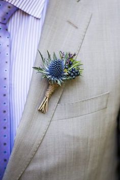 a man wearing a suit and tie with a boutonniere on his lapel