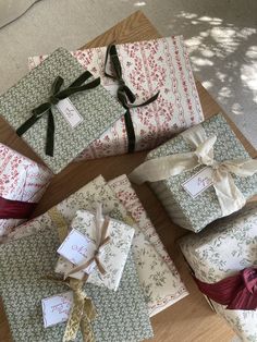 several wrapped presents sitting on top of a wooden table