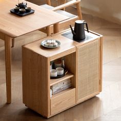 a wooden table with two chairs and a coffee pot sitting on it's side