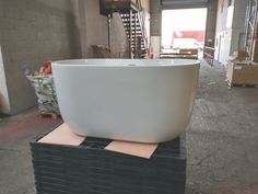 a large white bowl sitting on top of a stack of black boxes