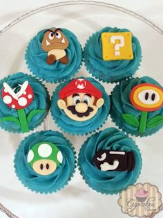 cupcakes decorated with fondant characters are on a glass platter, ready to be eaten