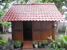 a small wooden building surrounded by plants and trees