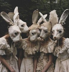 four people wearing bunny ears and dresses with rabbits on their heads are standing in front of each other