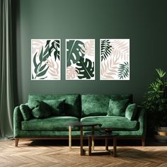 a living room with green walls and two paintings on the wall, one has pink and green leaves