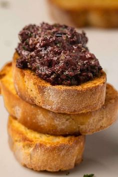 three pieces of bread stacked on top of each other topped with blueberry compote