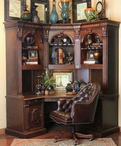 an old fashioned desk and chair in front of a large bookcase with pictures on it