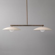 three lights hanging from a ceiling fixture in a room with gray walls and flooring