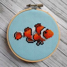 an orange clown fish cross stitched on a blue background