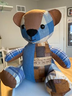 a blue and brown teddy bear sitting on top of a table