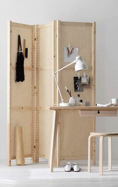 a room divider made out of wood with a desk and chair next to it