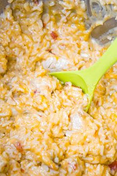 a green spatula in a pot filled with rice