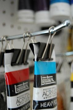 two tubes of acrylic are hanging on a rack in front of other items