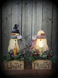 two snowmen sitting on top of wooden blocks with christmas decorations around them and the words winter frosty