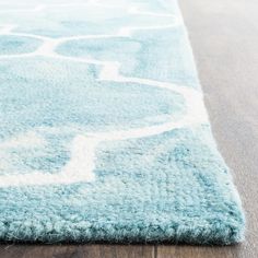 a blue and white rug on top of a wooden floor