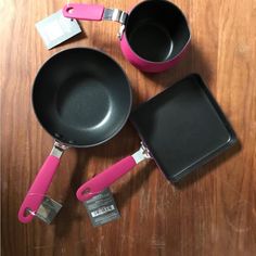 two pans and one spatula are sitting on the table next to each other