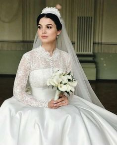 a woman in a wedding dress sitting down