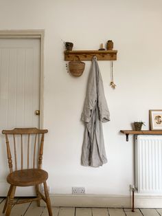 a wooden chair sitting in front of a white wall next to a radiator