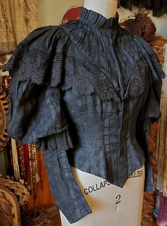 1890s bodice of black cotton. High collar, large puff sleeves Front closes with hook and eyes. Good condition. Spots down middle front. Two small tears at front. Wearable with care. 1890s Outfits, 1890s Bodice, Victorian Bodice, Structured Fashion, 1899 Fashion, Victorian Era Fashion, Historic Fashion, Edwardian Dress