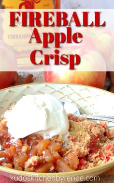 a bowl filled with apple crisp on top of a table next to an apple and whipped cream