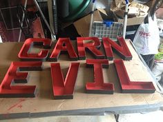 the word carn evil is made out of red plastic letters on a workbench