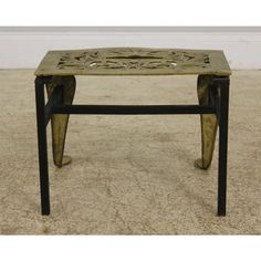 a small metal table with an intricate design on it