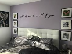 a bedroom with purple walls and pictures on the wall