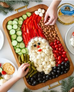 a platter filled with vegetables and veggies, including cauliflower, olives, cucumbers, tomatoes, beans, and cheese