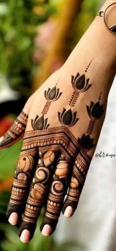 a woman's hand with henna tattoos on it