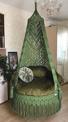 a bed with a green canopy hanging from it's side in a living room