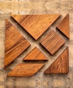 several pieces of wood are arranged in the shape of an abstract geometric pattern on a wooden surface