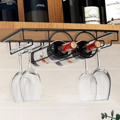 two wine glasses are hanging from a shelf