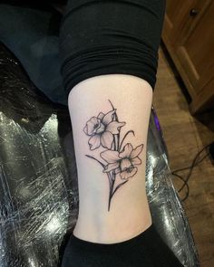 a small flower tattoo on the ankle that is sitting on a woman's leg